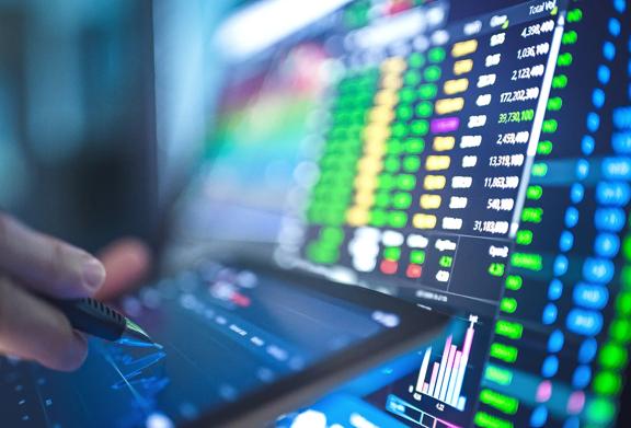 Close-up of financial market data on multiple screens with charts, graphs, and trading activity