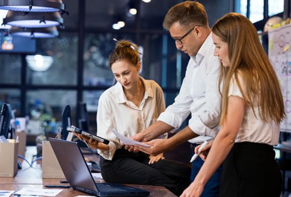Team of professionals reviewing documents and digital content during a collaborative office meeting