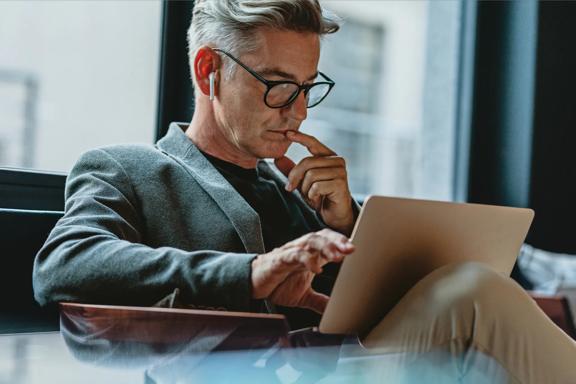 Professional reviewing content on a tablet in a contemporary office environment.