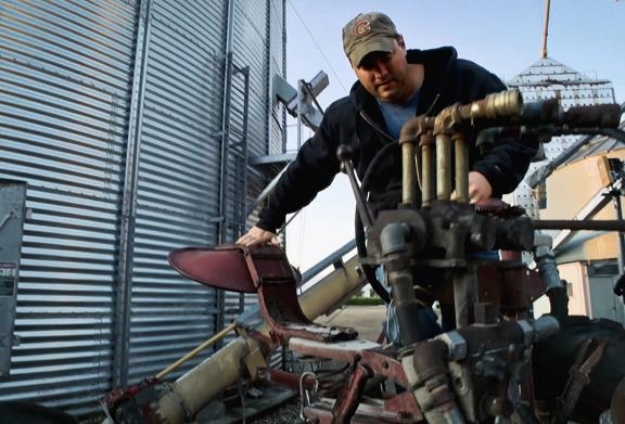 Farmer looking at machinery