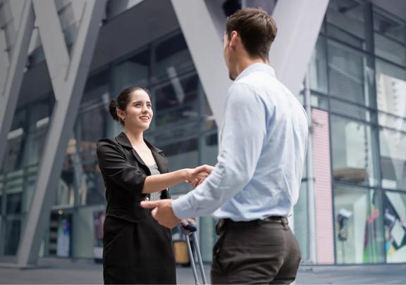 Business professionals shaking hands outside a modern office building