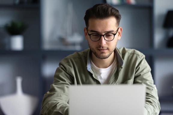 Professional using a laptop to manage investments and monitor financial markets