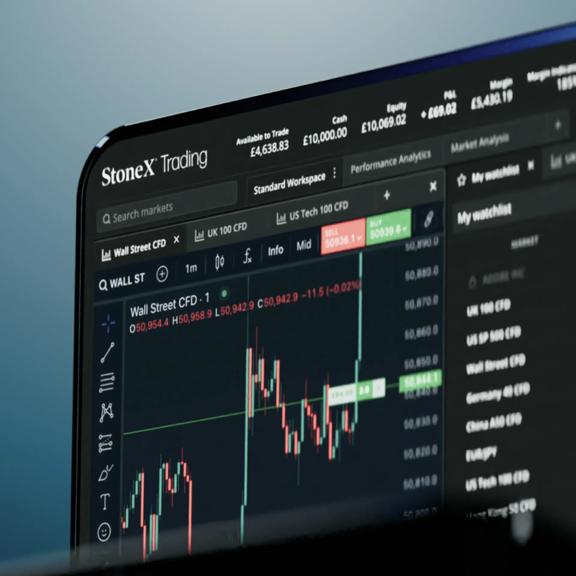 StoneX Trading platform displayed on a tablet showing charts and watchlist