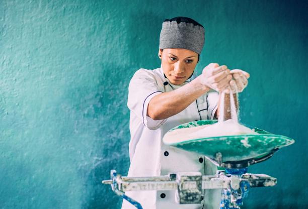 Cheesemaker stretching fresh mozzarella curds by hand in a traditional dairy facility