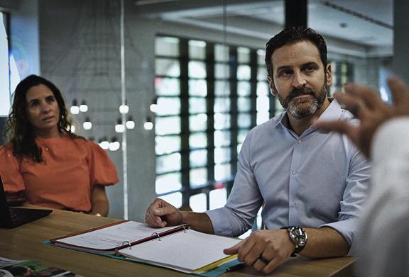 Business professionals in a meeting discussing strategy with documents and reports on the table