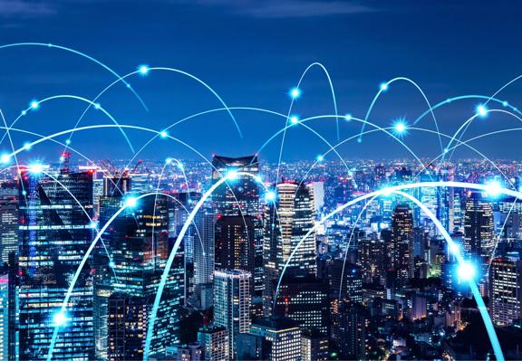 Nightime city skyline with digital network connections and global communication technology overlay