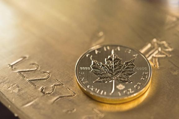 Canadian gold maple leaf coin on a gold bullion bar