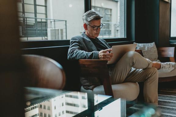Professional using a tablet device in a modern office environment, representing market research, investment analysis, financial decision making, and digital business productivity.