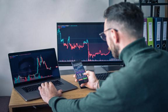 Financial expert analyzing the financial markets on multiple devices