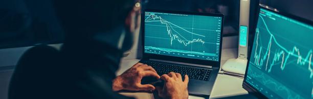 Foreign exchange traders analyzing market data on large screens in an office setting