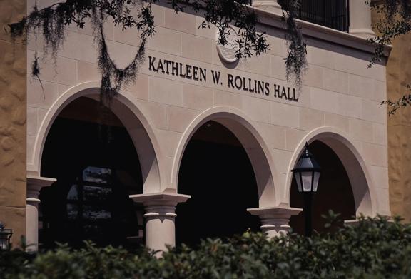 Exterior view of Kathleen W. Rollins Hall building with arched entrances and lantern lighting