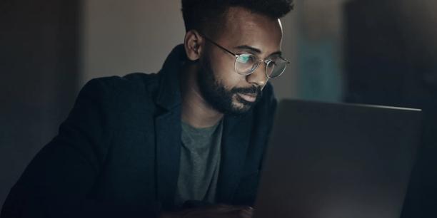 professional with glasses looking into laptop