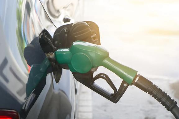 Bico de combustível abastecendo tanque de automóvel em posto de gasolina durante o reabastecimento de gasolina ou diesel.
