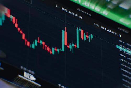 Close-up of a trading platform displaying a candlestick chart with price movements and market trends on a digital screen.