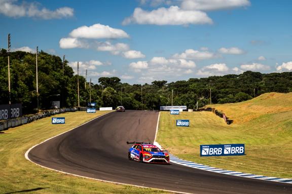 Carro da Scuderia Bandeiras competindo na Stock Car em curva do autódromo.