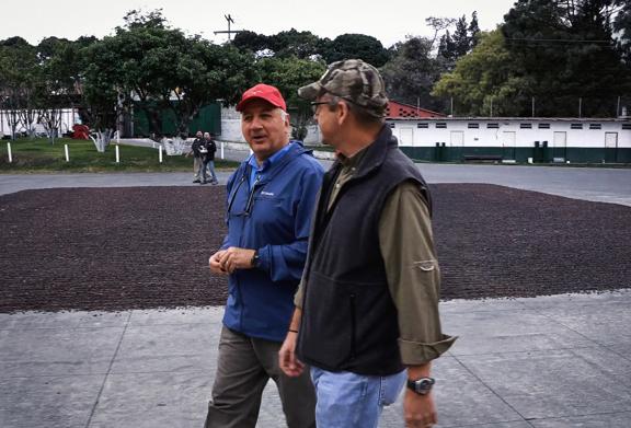 Two men walking wearing baseball caps