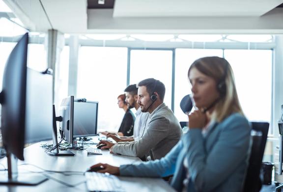 Equipe de suporte ao cliente trabalhando com fones de ouvido em um ambiente moderno de escritório de call center