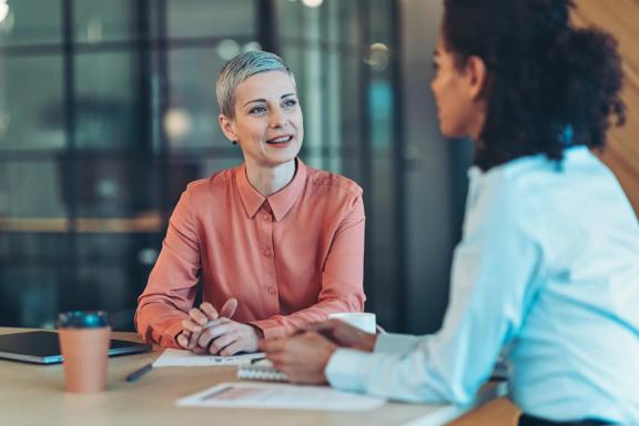 Two women meeting at table in modern office