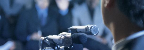Man standing in front of microphones for press briefing