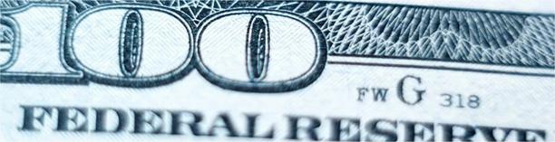 Close-up of US $100 bill with Federal Reserve seal, symbolizing monetary policy and US economy
