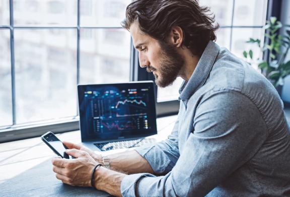 Modern investor monitoring market trends and trading insights across multiple devices