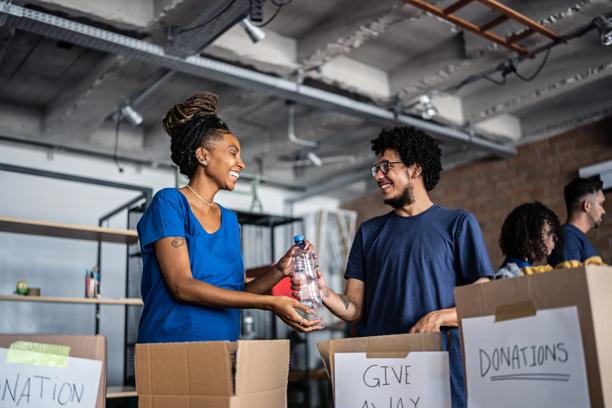 Two smiling people helping out at a community outreach center