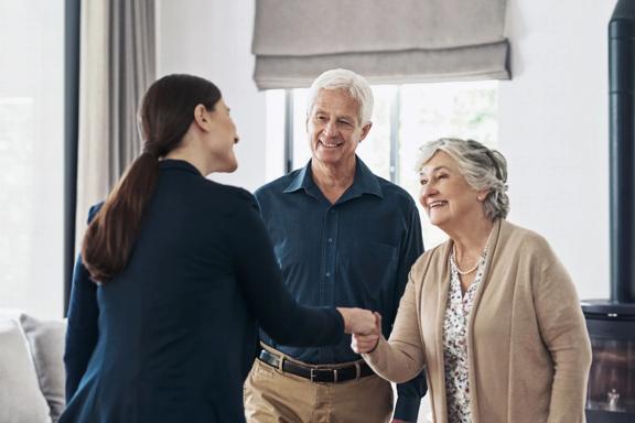 Older couple shaking hands with professional woman