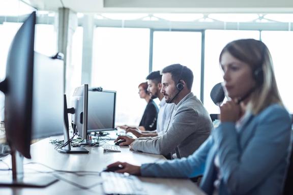 Customer support team assisting clients while working at computers