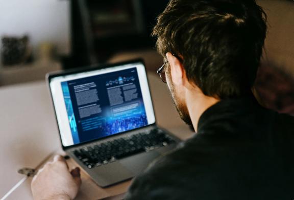 Man analyzing data and reading financial reports on a laptop screen
