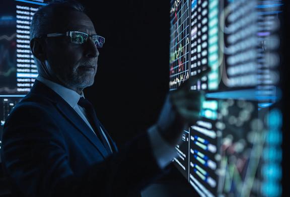 Professional man wearing glasses looking at screen on the wall