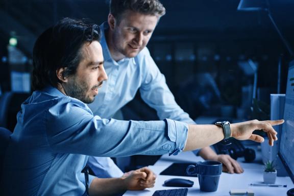 Two professional men working in darkened office