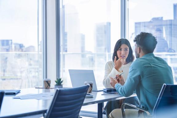 Professional business meeting in a modern office with two colleagues discussing strategy