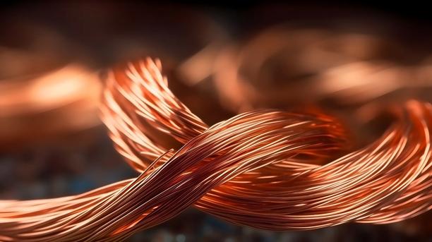 Close-up of intertwined copper-colored metal strands, with fine wire fibers visible and a blurred warm-toned background.