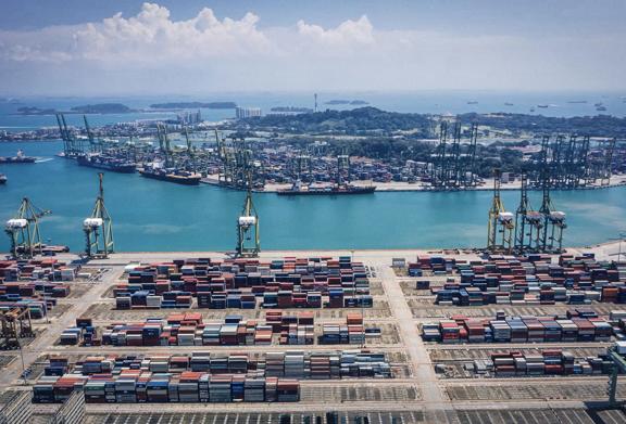 Aerial view of shipping port with stacked containers and cargo cranes