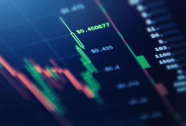 Close-up of a digital candlestick chart showing a downward market trend and price volatility
