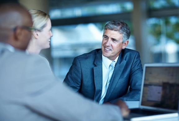 Business professionals discussing over tablet in office setting
